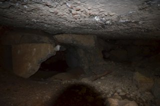 Под обвалившейся плитой кровли.