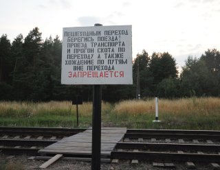 Предупредительная табличка на переходе у станции.